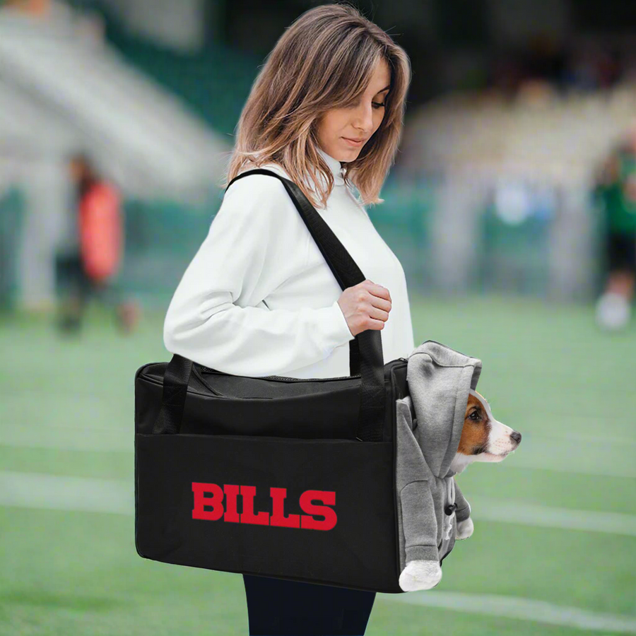 Woman carrying a dog in the Buffalo Bills pet carrier on a football field